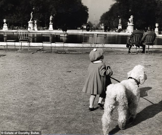 A girl walking her dog in the Tuileries Garden, Paris, 1953.