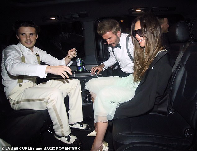 Victoria seemed in high spirits as David helped his wife into the back of a waiting car after the party.