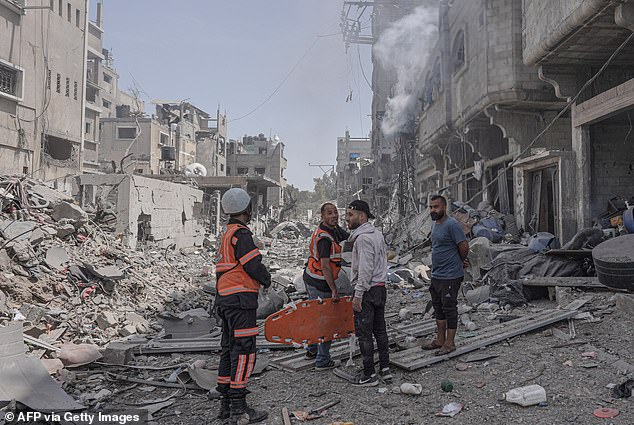 Palestinian medics gather at the site of an Israeli attack in the central Gaza Strip on April 22, 2024.