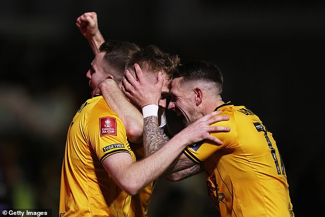Newport County players celebrate scoring a goal in their fourth round tie against Man United