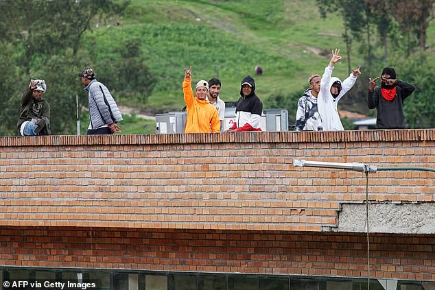 Inmates remain on the roof of the Turi prison, where they hold prison guards hostage, in Cuenca, Ecuador