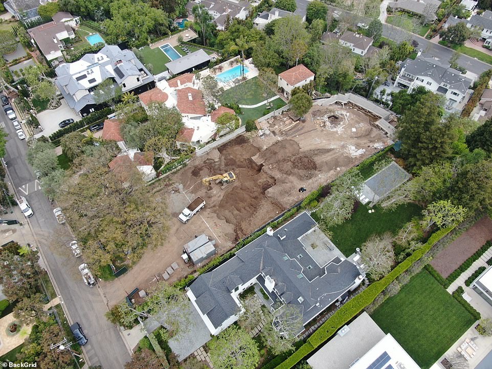 A large yellow crane with a wrecking ball, which was used to dismantle the property the couple bought for $12.5 million last year, and a white van were seen parked on the now-empty lot.