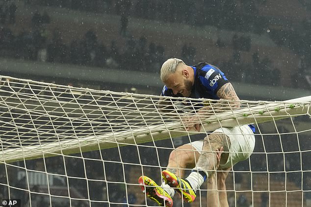 Inter Milan Federico Dimarco is helped onto the roof of the net as he celebrates