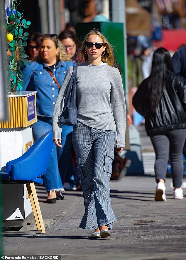 Lila was photographed in New York on Monday, looking chic in striped cargo pants and a gray sweater.