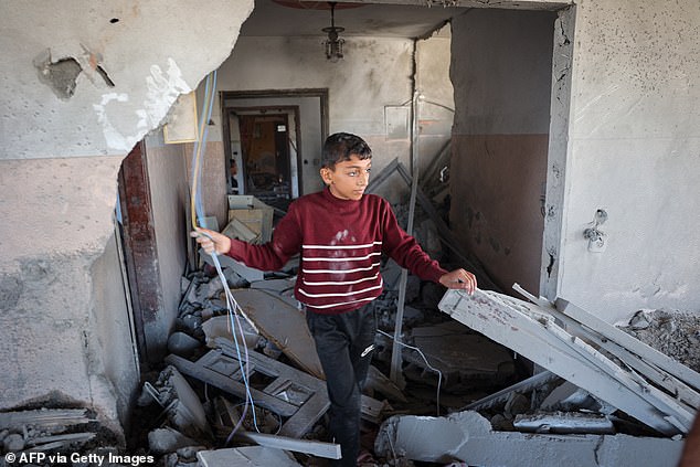 A Palestinian boy sifts through the rubble of a house hit by an Israeli bombardment overnight in Rafah.