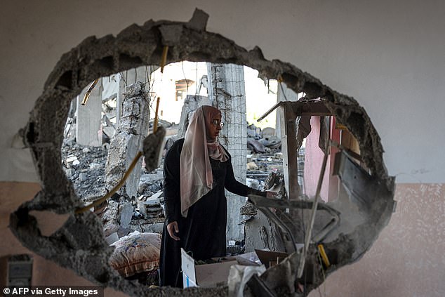 A Palestinian woman sifts through the rubble of a house hit by an overnight Israeli bombardment in Rafah, southern Gaza Strip, on April 20.