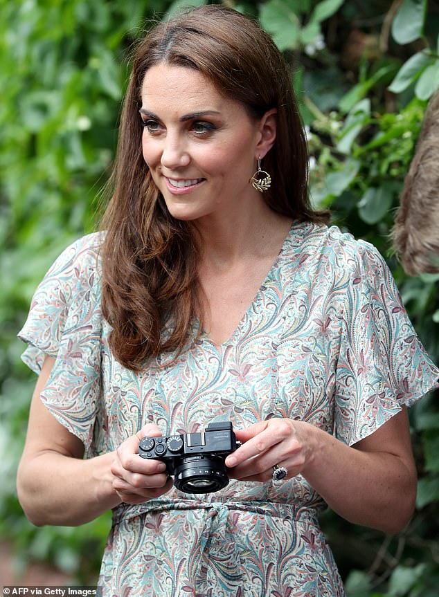The Princess of Wales pictured holding a camera while taking part in a photography workshop with the 'Action for Children' charity in Kingston in June 2019.