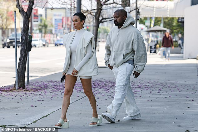 The 46-year-old rapper wore a cream hoodie, paired with baggy sweats, showing off his gray underwear as he strolled alongside his wife, 29, in Los Angeles.