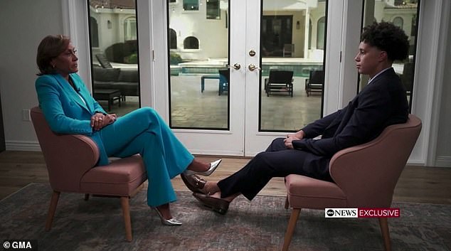 The 6-foot-9 Griner is seen with his legs extended in front of ABC's Robin Roberts.