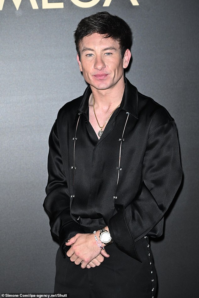 Barry Keoghan dressed up in an oversized black satin shirt that he tucked into a pair of matching pants.