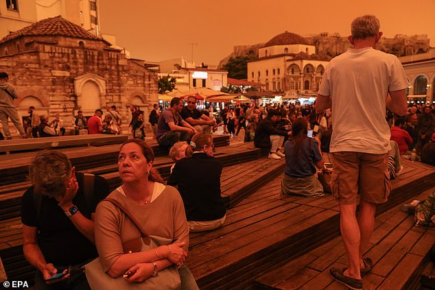 The sudden climate change also caused temperatures to soar, with the mercury reaching 30°C (86°F) on the southern island of Crete, more than 20°C (68°F) higher than most of northern Crete. Greece (pictured: people looking at the orange skies in Athens yesterday).