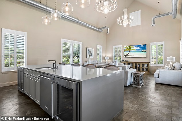 The modern kitchen features custom cabinetry and Viking appliances and a spacious dining room overlooking the custom glass sunroom with a stunning view of the backyard.