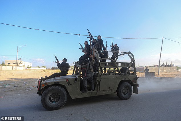 Palestinian militants ride in an Israeli military vehicle that was seized by gunmen who infiltrated areas of southern Israel, northern Gaza Strip, October 7, 2023.