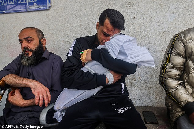 Palestinian father Ashraf cries as he holds the body of one of his two daughters after they were both killed in an overnight Israeli airstrike in Rafah, southern Gaza Strip, April 4, 2024.