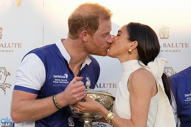 The Duke and Duchess of Sussex kiss as they present their polo team with the trophy for winning the Royal Salute Polo Challenge 2024 to benefit Sentebale, Friday, April 12, 2024.