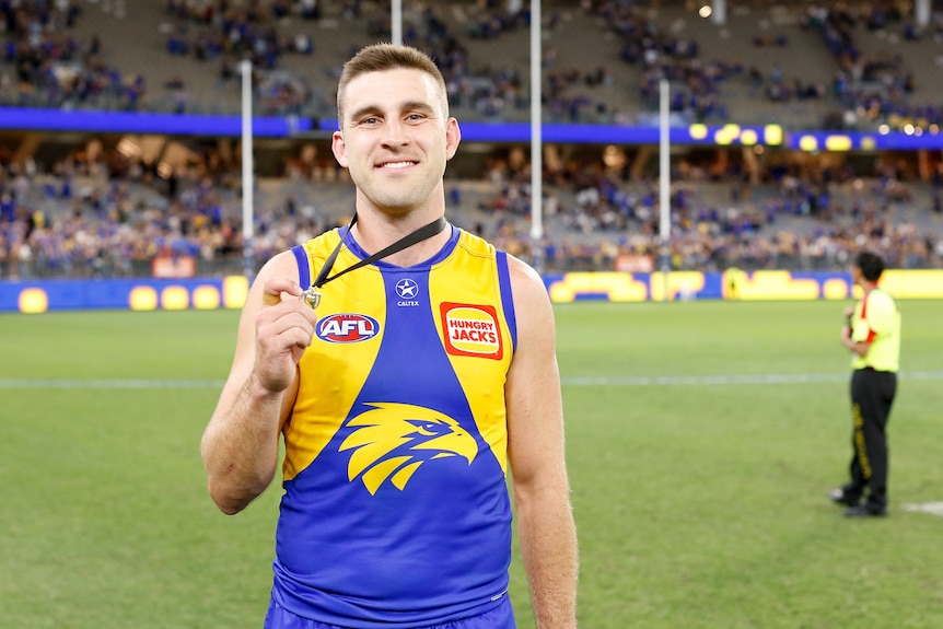 West Coast Eagles player Elliot Yeo smiles as he holds a medal. 