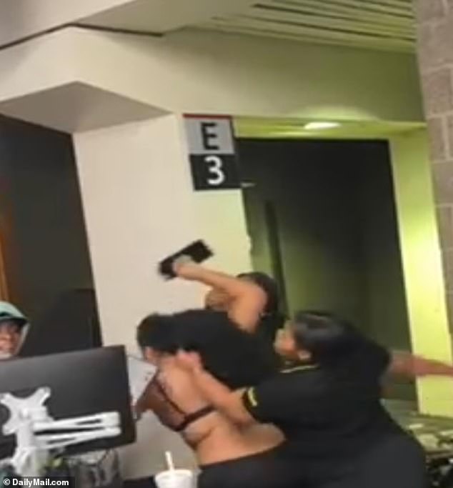 During a fight at a Spirit Airline terminal, a mother ran up to the counter and grabbed a keyboard, but was dragged away and punched in the head.