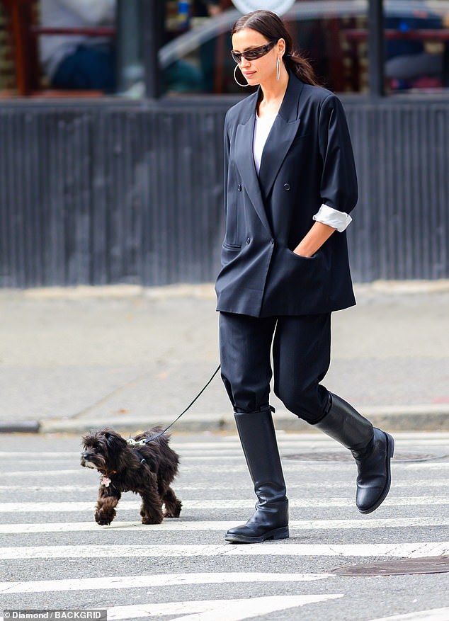 Irina completed her stylish look with a pair of black knee-high boots.