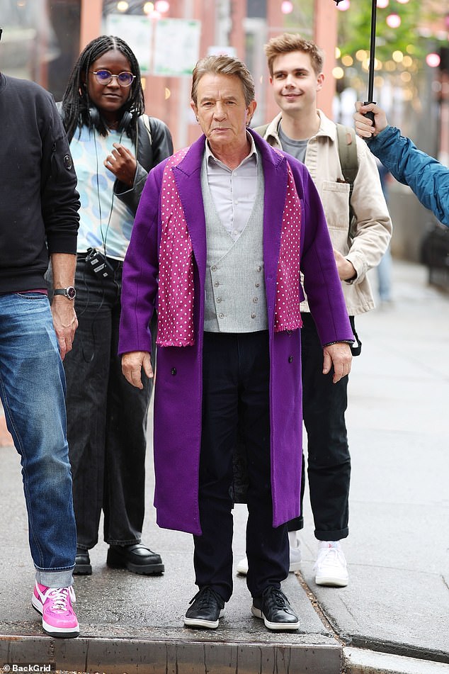 Martin wore a bold purple coat paired with a stylish vest and skinny pants.