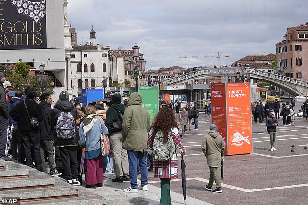 Tourists arrive outside the main train station in Venice, Italy, Wednesday, April 24, 2024.