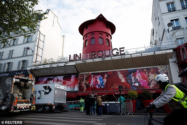The sails of the iconic red windmill atop the Moulin Rouge, Paris's most famous cabaret club, are seen on the ground.