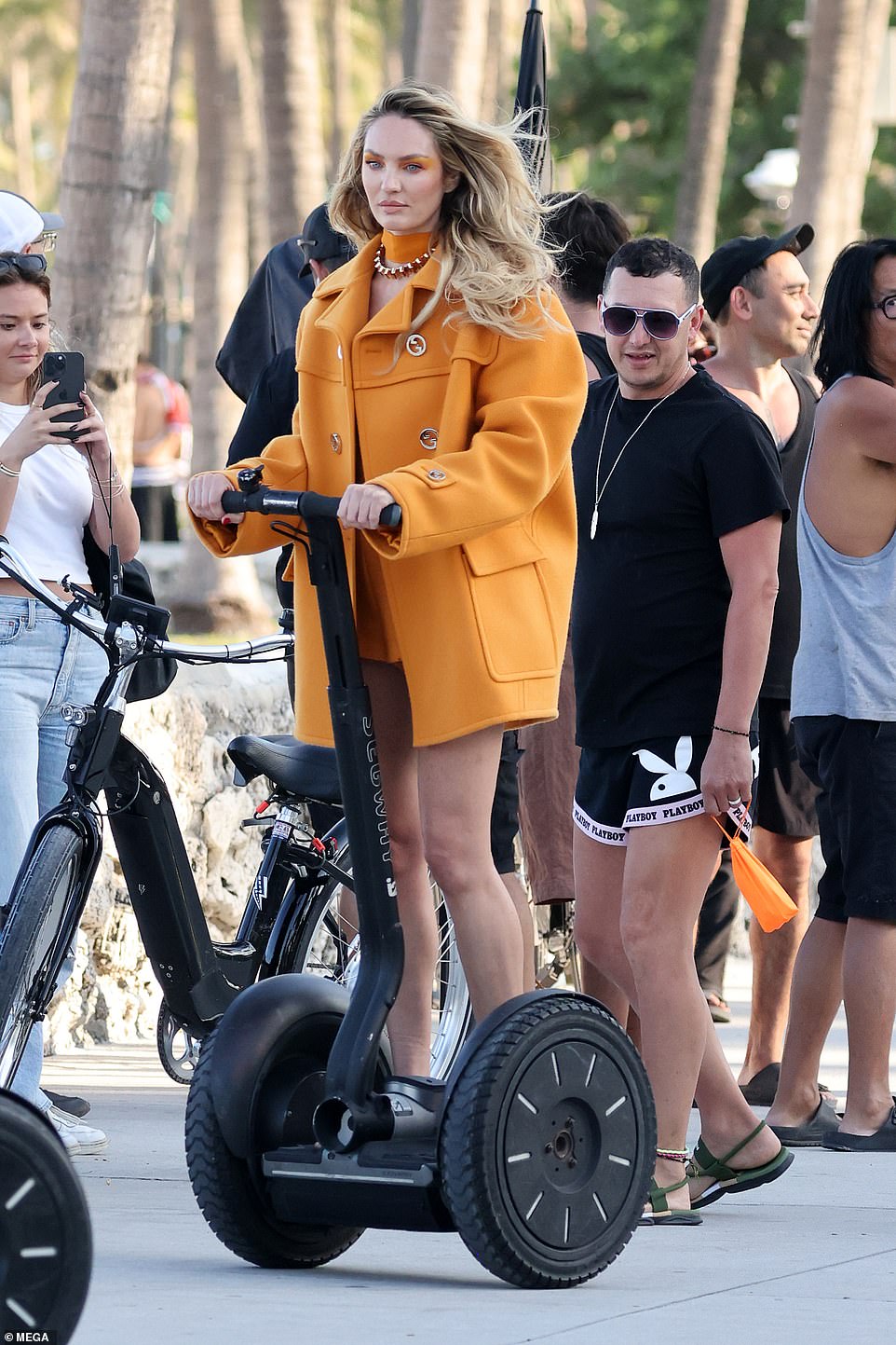 Candice showed off her legs in a thigh-high burnt orange dress, paired with the matching coat, which also had large gold buttons.