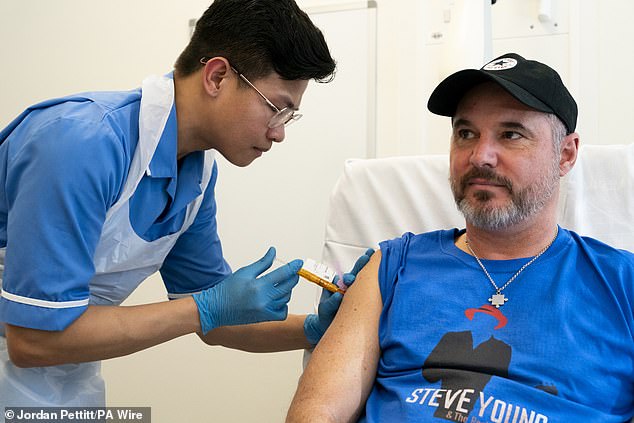 Nurse Christian Medina gives patient Steve Young his first injection at University College London Hospital.
