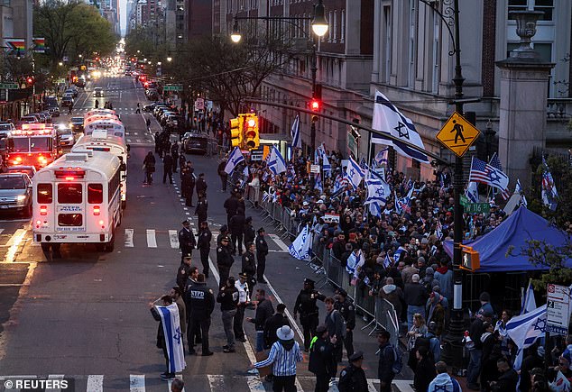 NYPD officers watch as people demonstrate in support of Israel outside the Columbia University campus amid the student protest camp in support of the Palestinians.