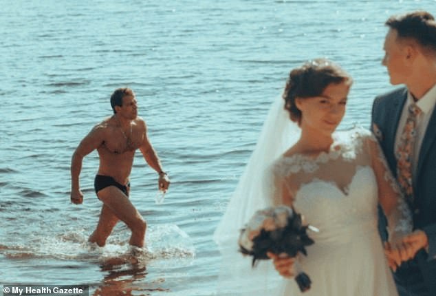 A happy couple posed for pictures on the beach, only for a swimmer to photograph the special moment.