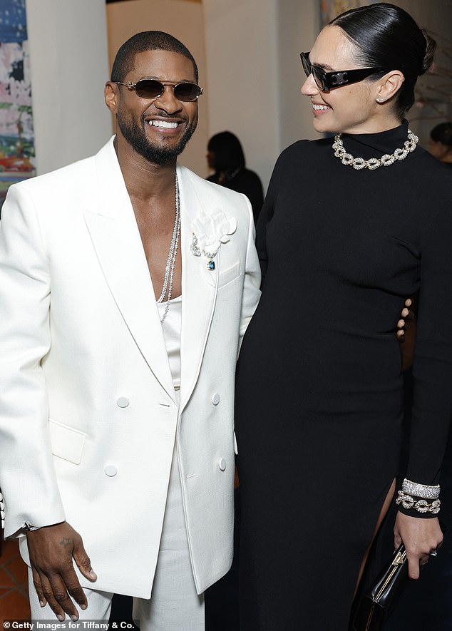 Gal smiled as she chatted with Usher, who modeled a white suit over a matching blouse that dipped tantalizingly to reveal his toned chest.