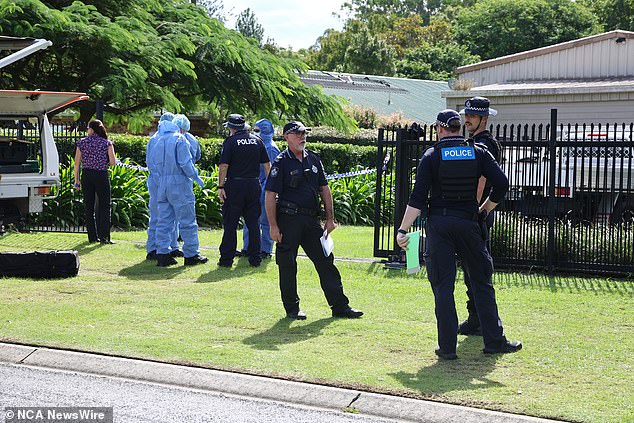Pictured: Police and investigators at the scene of the alleged murder on Friday.