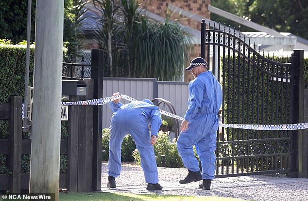Pictured: Police officers during a crime scene investigation on Friday.