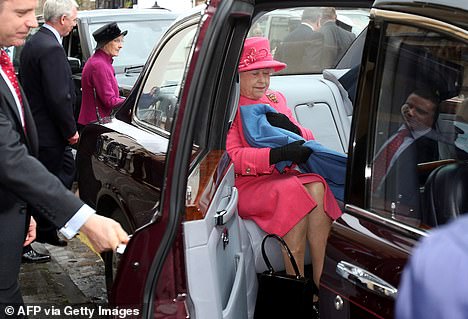 Queen Elizabeth appears to quickly cover her legs with a blanket as her car door opens.