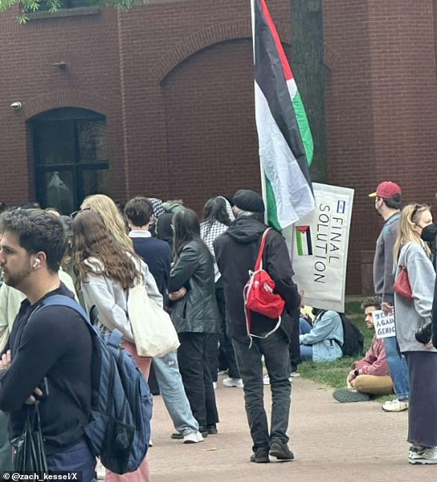 At George Washington University, a protester sparked outrage after being photographed holding a sign calling for 