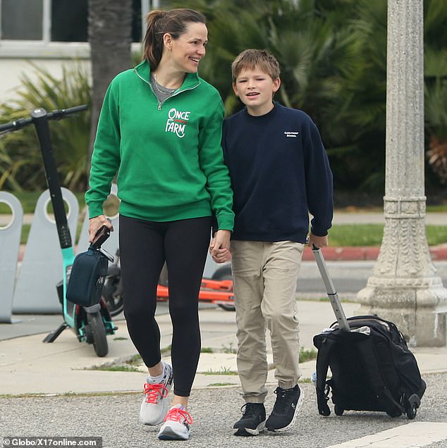 The 52-year-old entertainer smiled as she held the hand of her youngest son, 12, as they crossed the street, and then took a call as she prepared to return home for the day.
