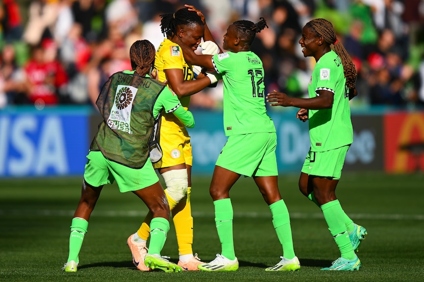 Three Nigerian teammates celebrate with Chiamaka Nnadozie after the Women's World Cup match against Canada.