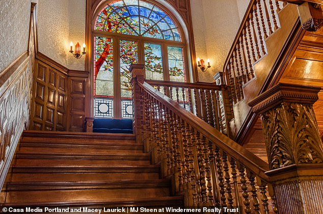 Seen here is a grand staircase complete with intricate wood carvings with beautiful stained glass.