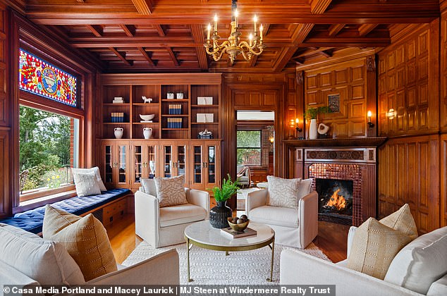 The cozy living room features comfortable chairs and a cozy fireplace.