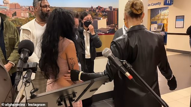 The activist showed up at a news conference Friday in a skintight bodycon dress with daring slits to make her case and plead for her job back, explaining that the vandalized flag she posed in front of was 