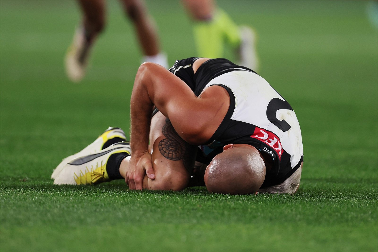 Sam Powell-Pepper lies on the ground injured for Port Adelaide.