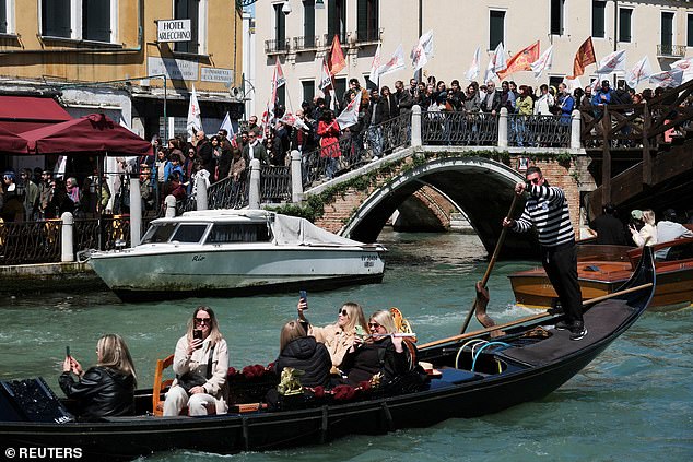 People with banners protest against the introduction of the tourist tax in Venice