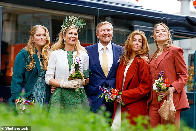 Queen Maxima of the Netherlands looked typically elegant in an olive green dress and statement headdress as she and her family attended King's Day celebrations today.