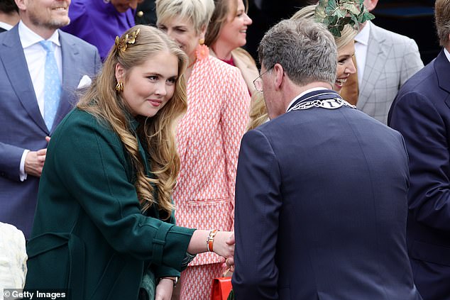 Princess Amalia shakes hands with an attendee during King's Day celebrations