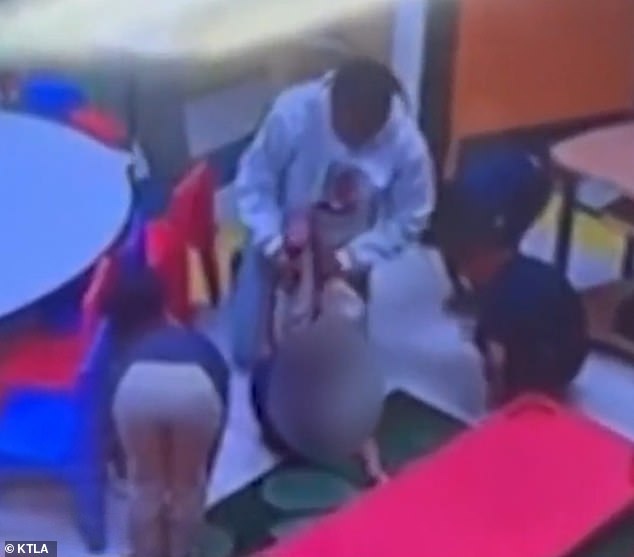 At the end of the footage, the employee can be seen holding the child face down before he appears to be placed on a table.
