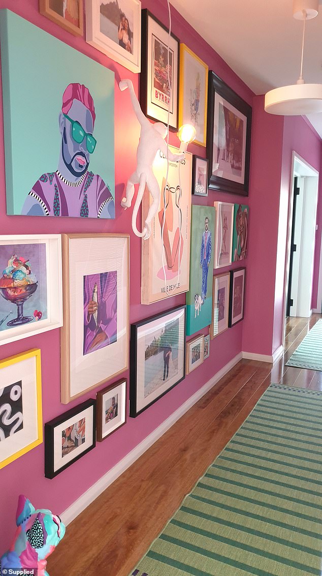 After entering the home, guests are immediately drawn to the pink art wall at the end of the hallway (pictured)