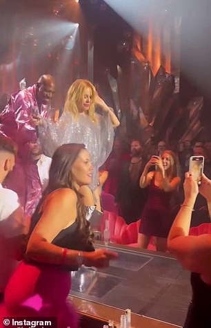 The videos show Kylie performing in a sparkly silver dress and thigh-high boots.