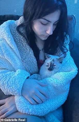 Another victim, Gabrielle Real, 23, with her cat Hela.