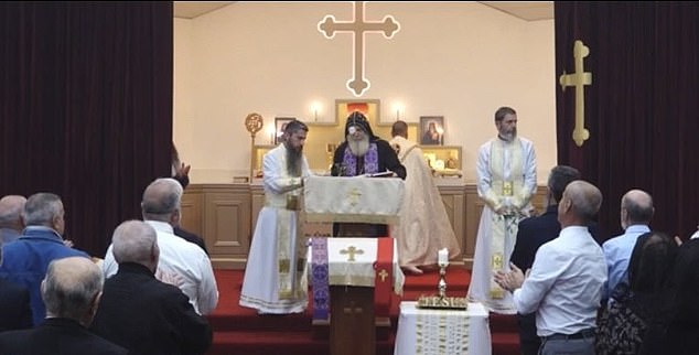 Bishop Mar Mari Emmanuel (pictured center) delivered the Orthodox Palm Sunday sermon on Sunday afternoon, wearing an eyepatch over his right eye.  he is pictured during a standing ovation
