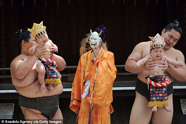 Sumo wrestlers gently try to get a reaction from babies, using a variety of playful techniques including grunting.