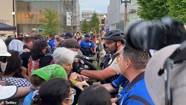Stein fights with law enforcement who were pushing back protesters with a bicycle